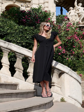 A woman wears a black dress